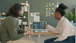 ノートパソコンを見ながらAI動画広告と商談データを分析する二人